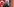 Eine Person mit Kopftuch vor der deutschen und türkischen Flagge