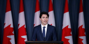 Der kanadische Premierminister Justin Trudeau vor Fahnen seines Landes