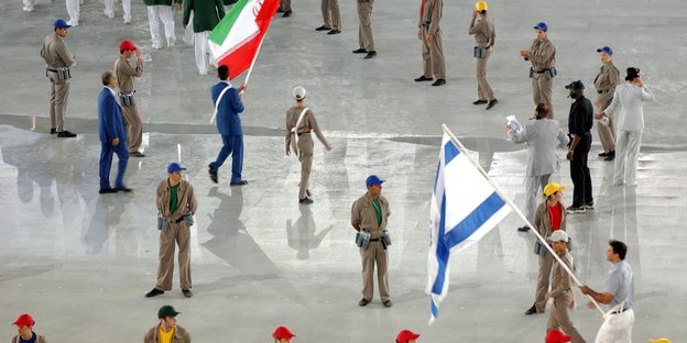 die Fahnenträger Irans und Israels umringt von Helfern