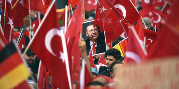 Ein Plakat von Erdogan ist umgegeben von türkischen Flaggen