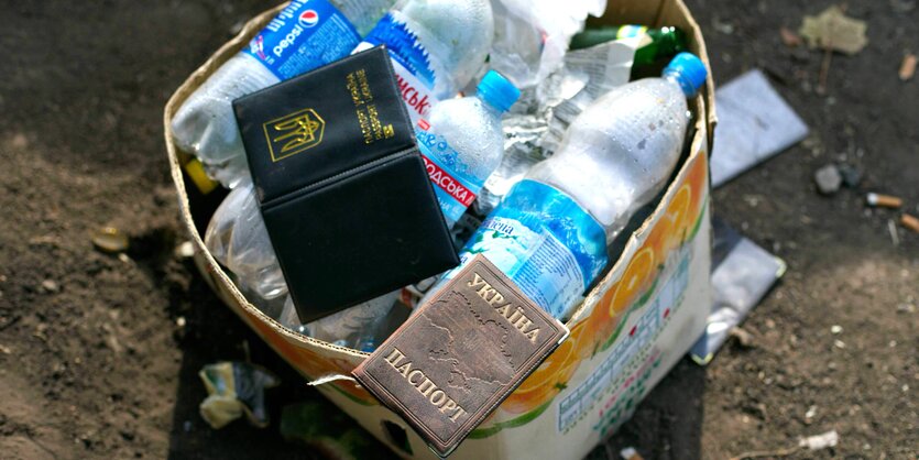 zwei Pässe auf einem Karton mit leeren Wasserflaschen aus Plastik