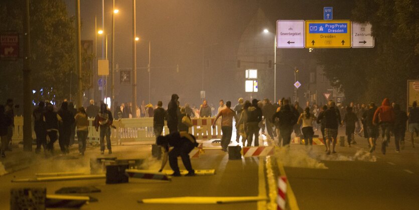 Ausschreitungen auf einer von Laternen erleuchteten Straße in Heidenau