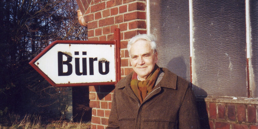 J.J. Voskuil neben einem Schild, auf dem Büro steht