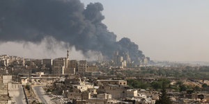 Rauch steigt von einem Gebäude in Aleppo auf