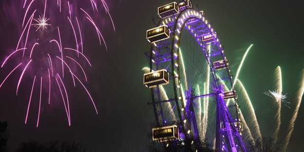 Ein Riesenrad vor einem Himmel voller Feuerwerk