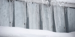 Eiszapfen hängen an einem Dach