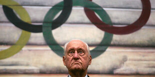 Kopf von Havelange am unteren Bildrand, mittig. Dahinter an der Wand die 5 olympischen Ringe