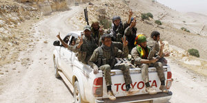 Jeep mit bewaffneten Kämpfern
