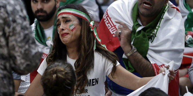 Ein weiblicher Sportfan mit grün-weiß-roter Bemalung