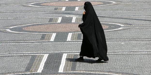 Eine Frau in einer Burka geht über den Odeonsplatz in München