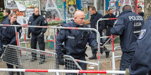 Polizisten tragen Absperrgitter vor der Rigaer94