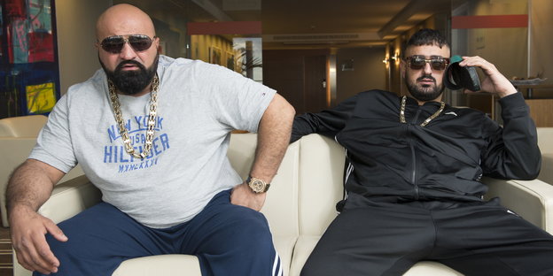 Die Rapper Xatar und Haftbefehl sitzen auf einem Sofa