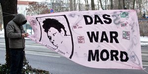 Ein Banner mit Oury Jallohs Gesicht und dem Schriftzug „Das war Mord“