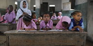 Mehrere junge Mädchen sitzen einem Klassenzimmer