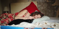 Nathalie (Isabelle Huppert) liegt auf dem Bett und streichelt eine Katze.