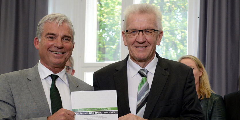 Kretschmann und Strobl halten den Koalitionsvertrag zwischen sich