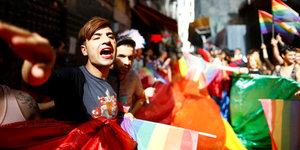 Menschen mit Regenbogenflaggen auf einer Straße