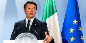 Matteo Renzi steht an einem Pult vor einer Europaflagge mit fünf Sternen