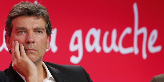 Der französische Politiker Arnaud Montebourg vor rotem Hintergrund, auf dem "gauche" steht