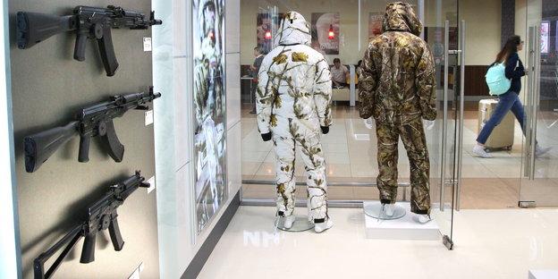 Tarnanzüge und Sturmgewehr-Attrappen sind in einem Laden ausgestellt