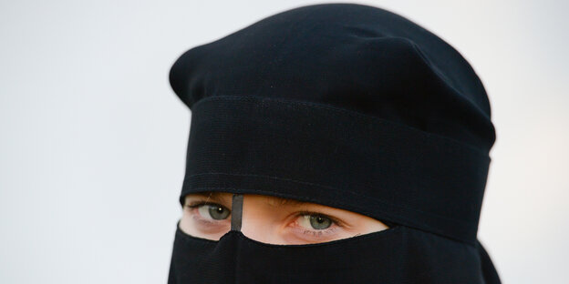Eine Frau trägt Nikab, einen Gesichtsschleier, der nur die Augen freilässt.