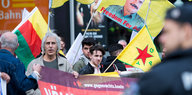 Männer mit YPG- und kurdischen Fahnen bei einer Demo