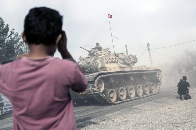 Ein Junge beobachtet einen vorbeifahrenden Panzer