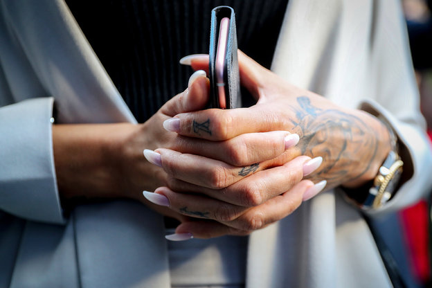 Eine Frau hat ihre Hände um ihr Handy gelegt