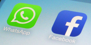 Zwei Symbole zeigen die Apps Whatsapp und Facebook auf einem Smartphone an