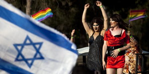 Im Vordergrund die israelische Flagge, im Hintergrund tanzende Drag Queens mit Regenbogenfahnen