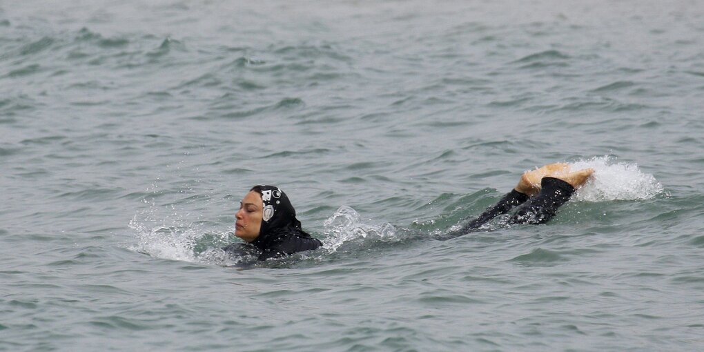 Eine Frau badet im Burkini