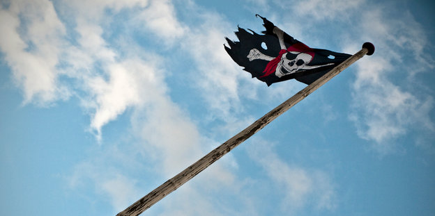 Piratenflagge vor blau-weißem Himmel
