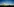 Auf einer Wiese steht ein Windrad neben einem Kohlekraftwerk im Hintergrund