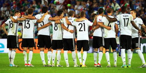 Spieler der DFB-Mannschaft stehen Arm in Arm in einer Reihe