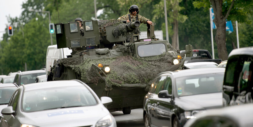 Ein Militärfahrzeug zwischen Autos