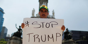 EIn Anti-Trump-Demonstrant hält in Mexiko ein Schild hoch mit dem Hashtag Stop Trump