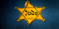 Ein gelber Stern, auf dem "Jude" steht, vor blauem Hintergrund