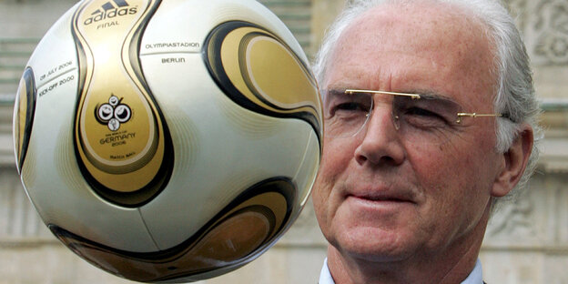 Franz Beckenbauer mit einem Ball auf Augenhöhe