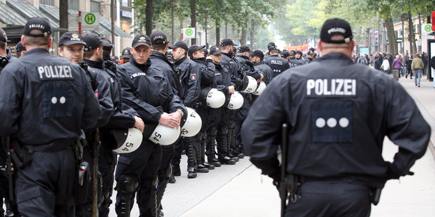 Viele Polizisten stehen mit Demonstrationsausrüstung auf einer Straße in Hamburg