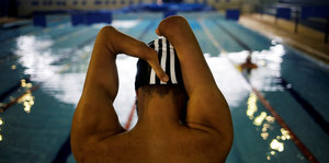 Der paralympische Schwimmen Daniel Dias am Beckenrand. Dias hat keine Unterarme