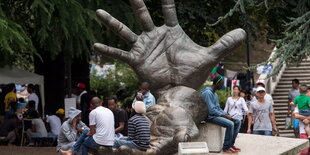 Flüchtlinge vor einem Denkmal