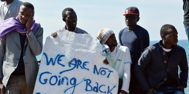 Migranten an der französisch-italienischen Grenze in Ventimiglia halten ein Plakat mit der Aufschrift "We are not going back"
