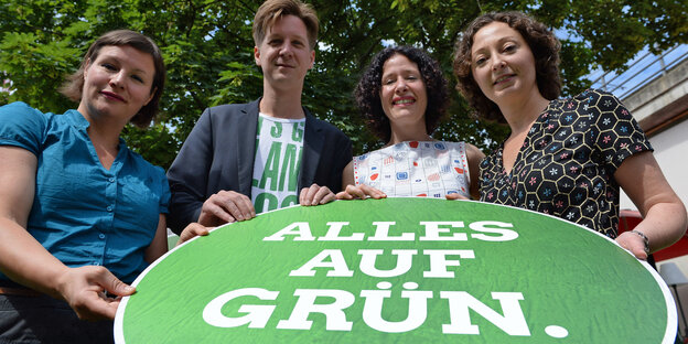 die vier Spitzenkandidatinnen und -kandidaten der Berliner Grünen, Antje Kapek, Daniel Wesener, Bettina Jarasch und Ramona Pop, halten ein Schild, auf dem steht: "Alles auf Grün"
