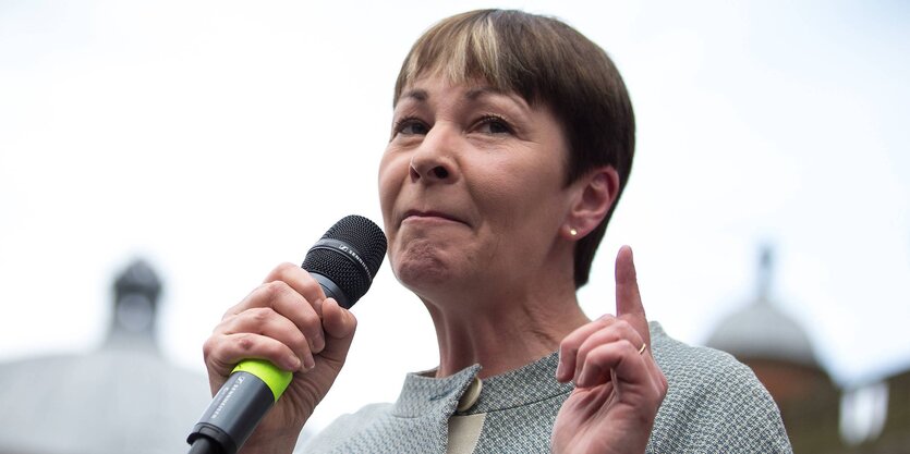 Caroline Lucas im Porträt mit Mikro in der Hand