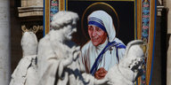 Ein Wandbild von Mutter Teresa hinter römischen Skulpturen