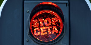 Im roten Licht einer Ampel steht der Schriftzug "Stop Ceta"