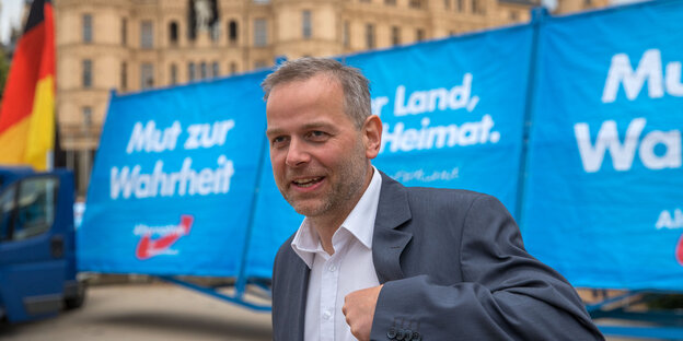 AfD-Spitzenkandidat Leif-Erik Holm steht vor AfD-Wahlplakaten