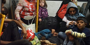 Menschen sitzen auf dem Boden eines Busses