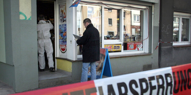 Polizeibeamte untersuchen nach dem Mord an Kioskbesitzer Mehmet Kubasik in Dortmund einen Kiosk auf Spuren