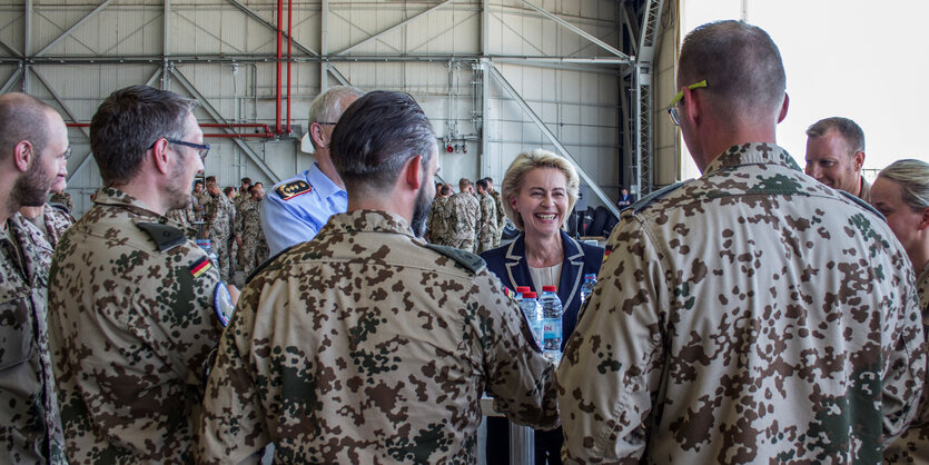 Ursula der Leyen hinter einem Kreis von Soldaten